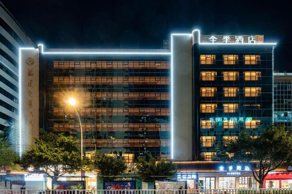 a tall building with lights on it at night at Ji Hotel Fuzhou Wuyi Square in Fuzhou