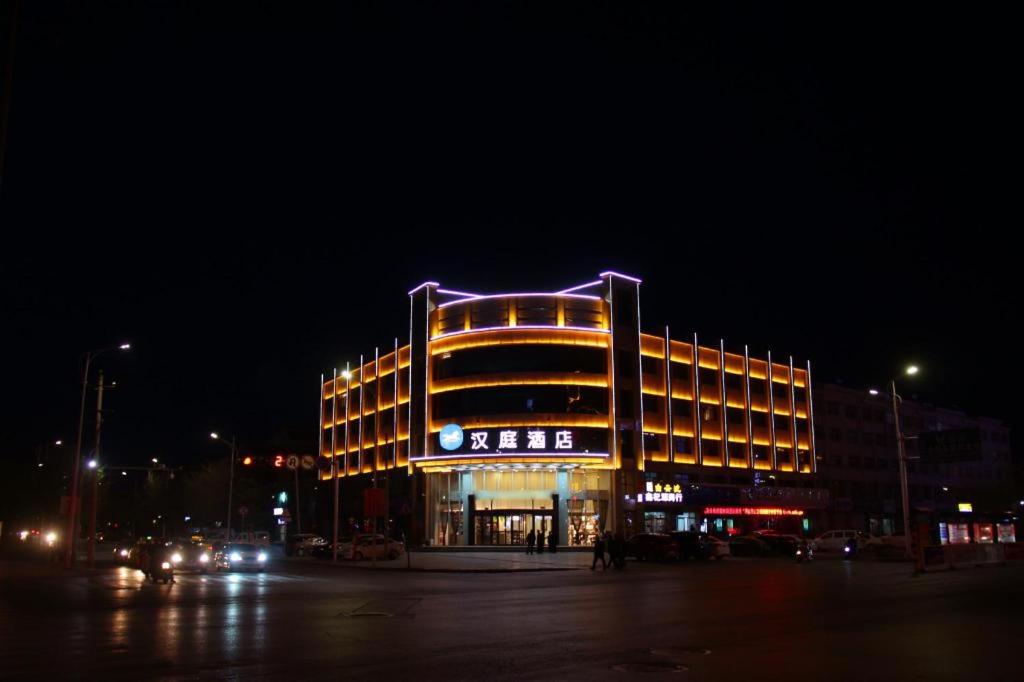 um grande edifício com uma luz roxa no topo à noite em Hanting Hotel Zhongwei Gulou Dong Street em Zhongwei