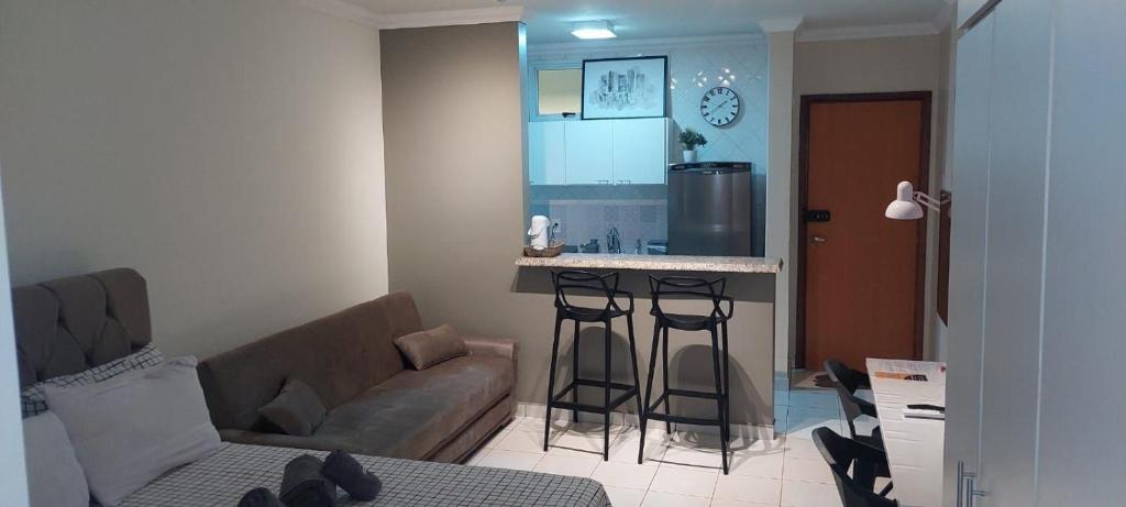 a living room with a couch and a kitchen at Edifício Belluno in Ribeirão Preto