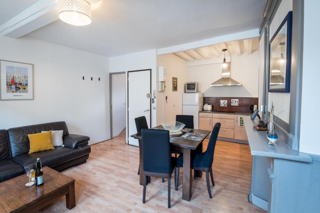 sala de estar con mesa y sofá en Le duplex de Lise, en Honfleur