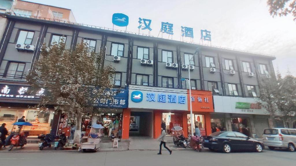 a person walking in front of a building at Hanting Hotel Chuzhou Dingyuan Shopping Building in Dingyuan