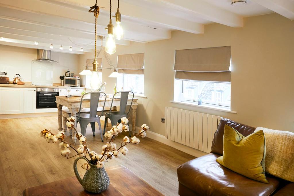 a living room with a table and a dining room at Glasswing Stays The Nest in Whitby