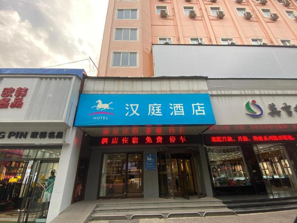 a building with a blue sign on the front of it at Hanting Hotel Changzhi Town God Temple in Changzhi