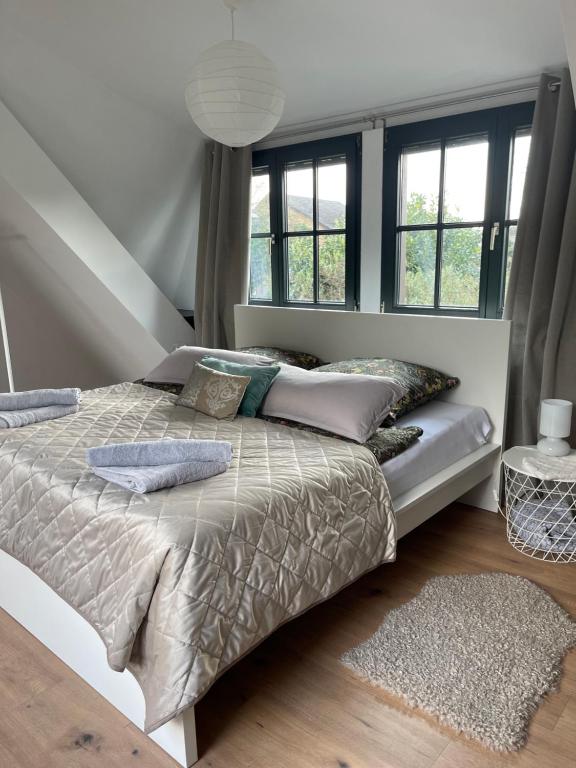 a bedroom with a bed with pillows and windows at Charmante Wohnung im Hinterhof in Neukirchen-Vluyn