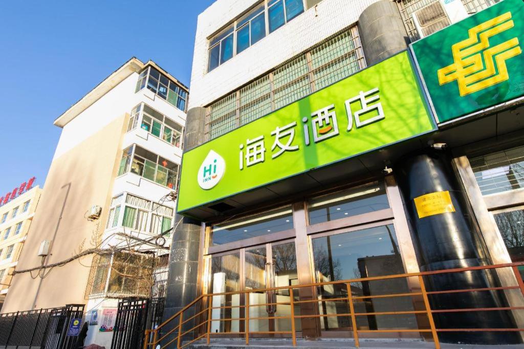 un edificio con una señal verde en el costado. en Hi Inn Taiyuan Jianshe North Road Taitie Plaza en Taiyuán