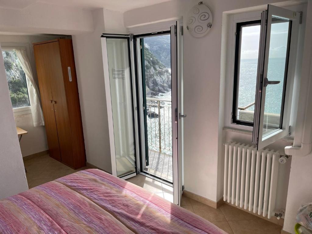 1 dormitorio con cama y vistas al océano en affittacamere nuova Vandiris en Manarola