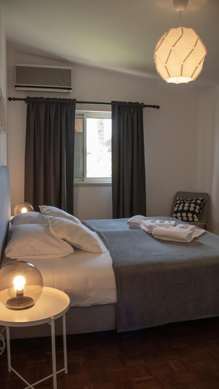 a bedroom with a large bed and a table at Pine House - Faro Airport, Beach and City Center in Faro