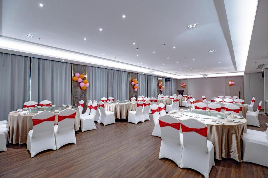 a banquet hall with white tables and white chairs at Hanting Hotel Nanjing Garden City Maihua Road in Yen-tzu-chi