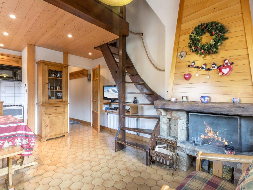 - un salon avec une cheminée et un escalier dans l'établissement 3* Calme, ensoleillé, garage, balcon, cheminée - FR-1-304-193, à La Clusaz