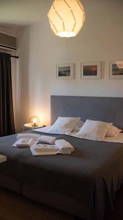 a bedroom with a large bed with towels on it at Pine House - Faro Airport, Beach and City Center in Faro