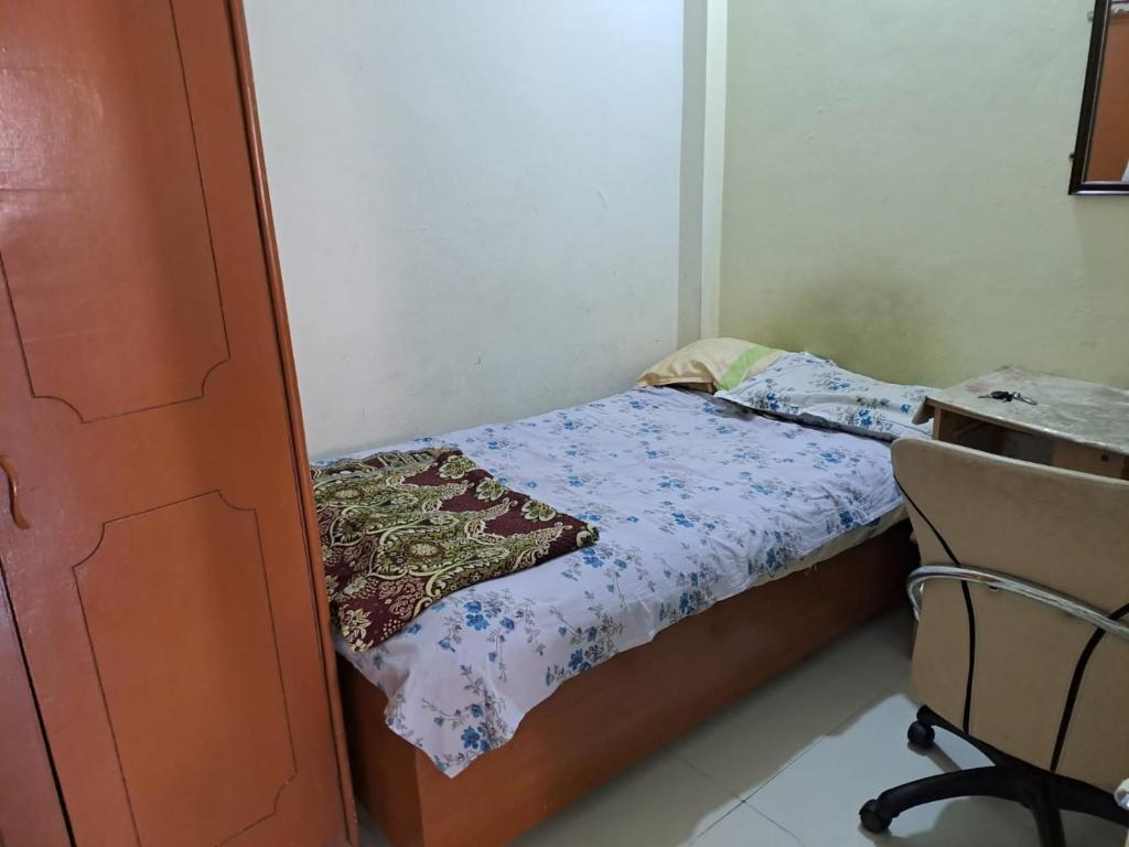 a small bedroom with a bed and a chair at Home Stay - PG in Indore
