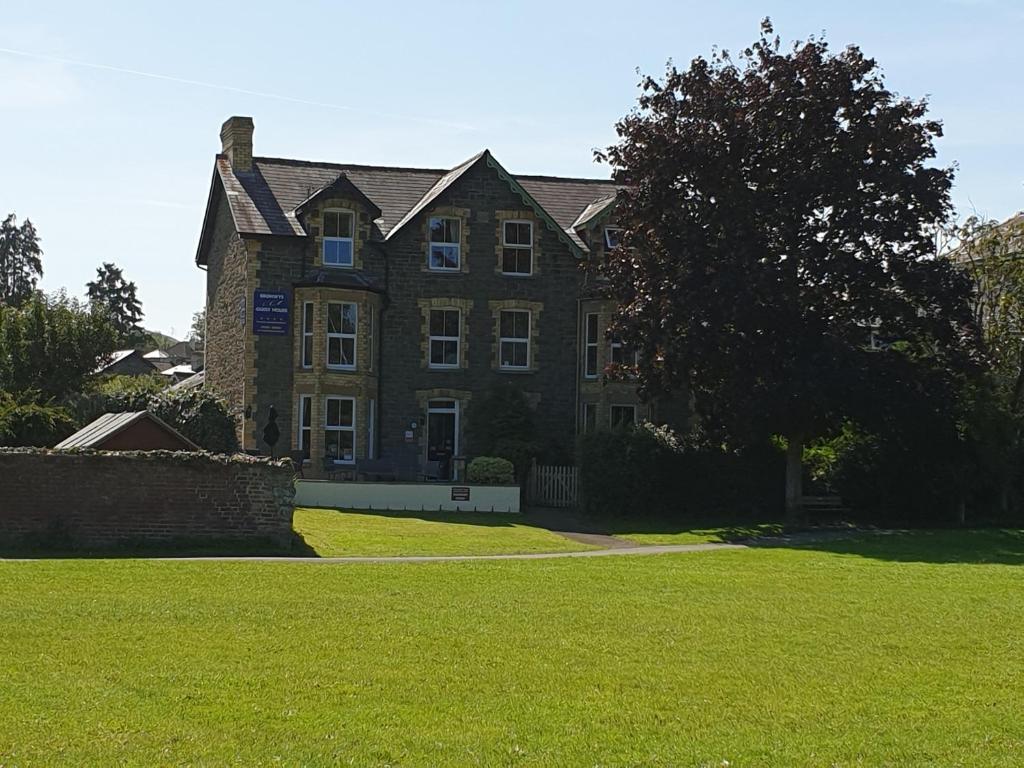 uma grande casa de tijolos com um relvado verde em frente em Bronwye em Builth Wells