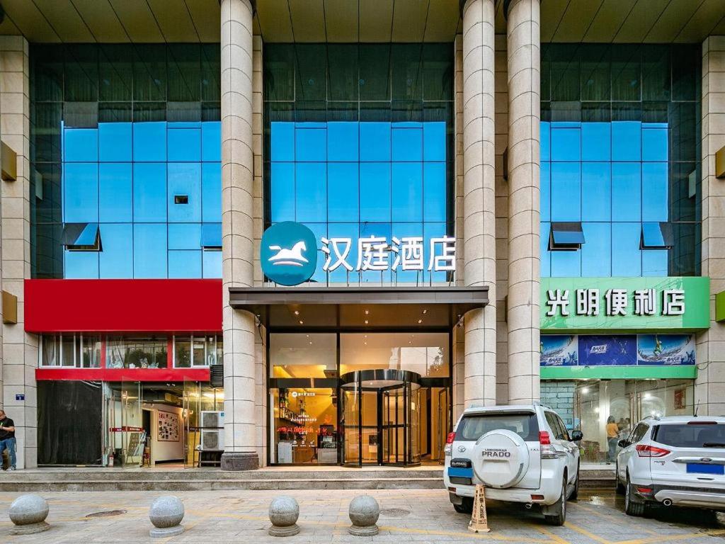 un edificio con coches estacionados frente a él en Hanting Hotel Yan'An Railway Station en Yan'an
