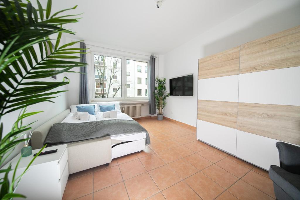 een slaapkamer met een bed en een groot raam bij Apartment - Central with Balcony - Kitchen & More in Düsseldorf