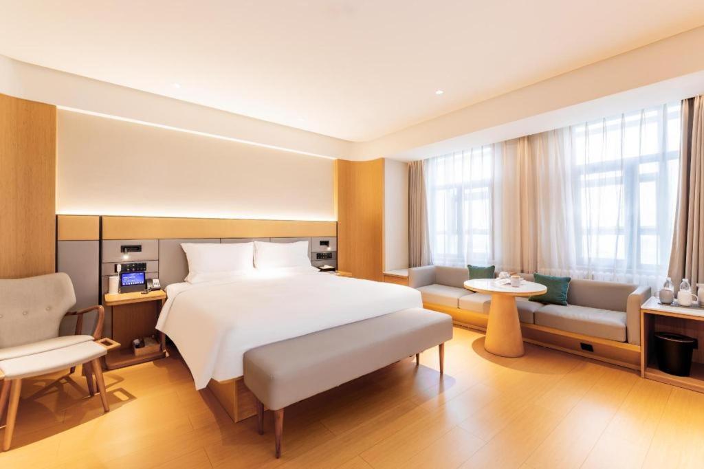 巴彥淖爾的住宿－Ji Hotel Bayanzhuo'Er Books Tower，卧室配有一张白色的大床和一张沙发。