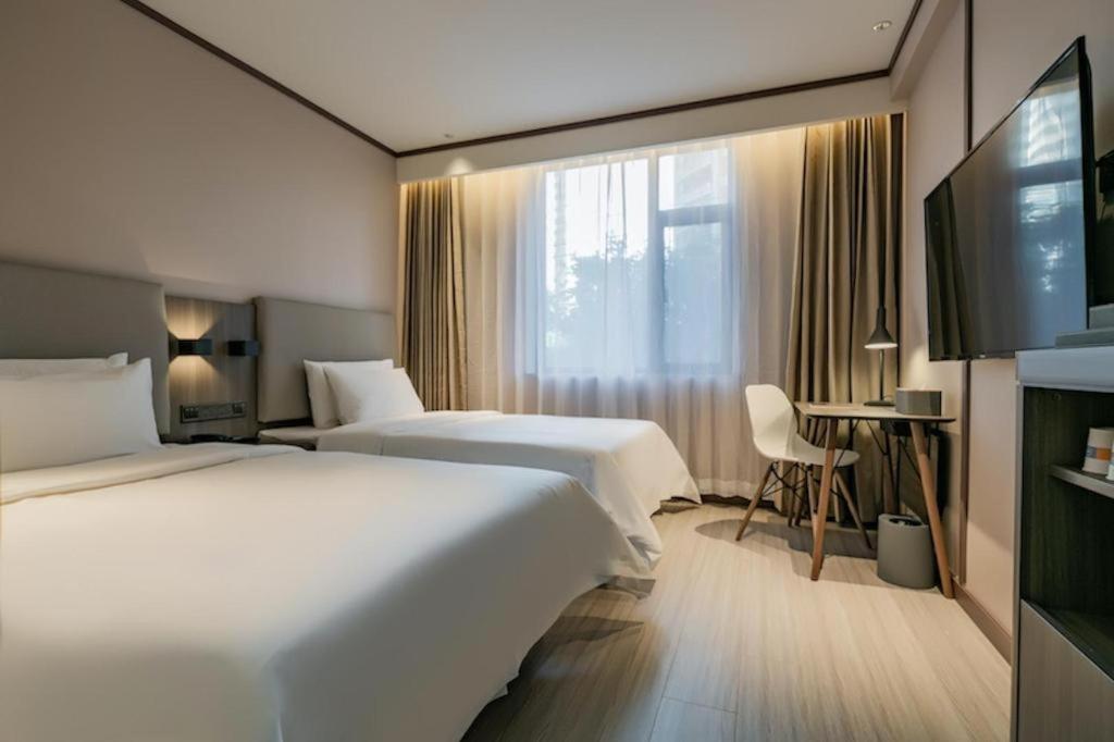 Ein Bett oder Betten in einem Zimmer der Unterkunft Hanting Hotel Kashgar Tumushuk