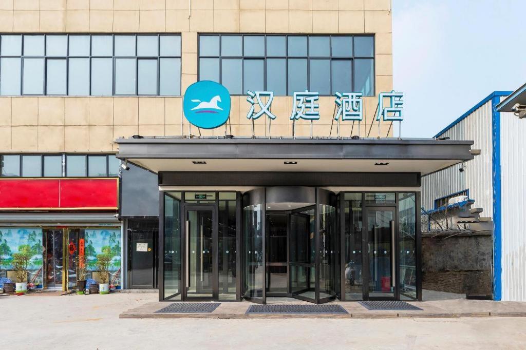 einen Eingang zu einem Gebäude mit einem Schild darauf in der Unterkunft Hanting Hotel Zhengzhou South Longhu Shawoli Metro Station in Guodian