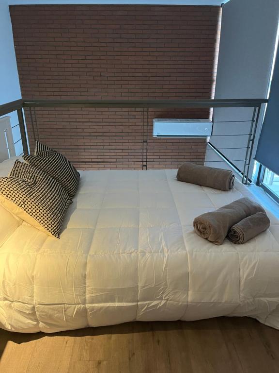 ein Bett mit zwei Kissen darüber in der Unterkunft NR apart in Santiago