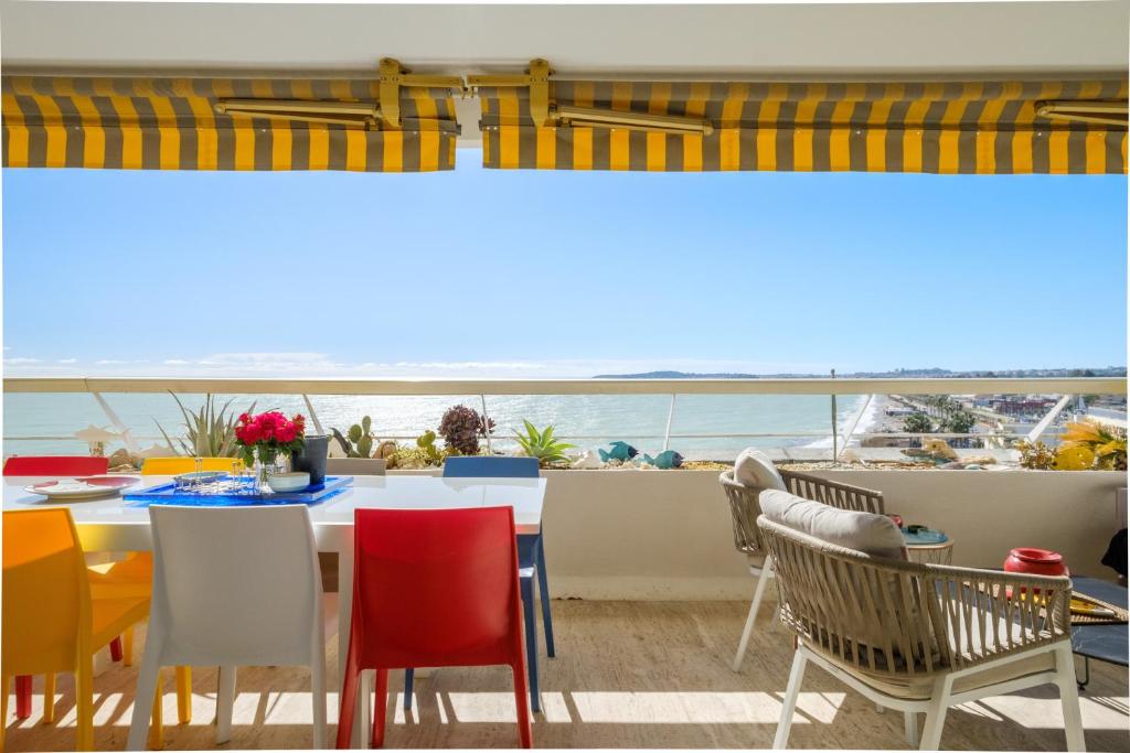 une salle à manger avec vue sur l'océan dans l'établissement Appartement Marina Baie des Anges, à Villeneuve-Loubet