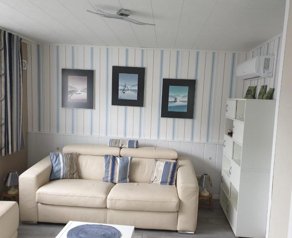 a living room with a white couch and pictures on the wall at Ferienhaus in Sassnitz - klein aber fein bis 4 Personen in Sassnitz
