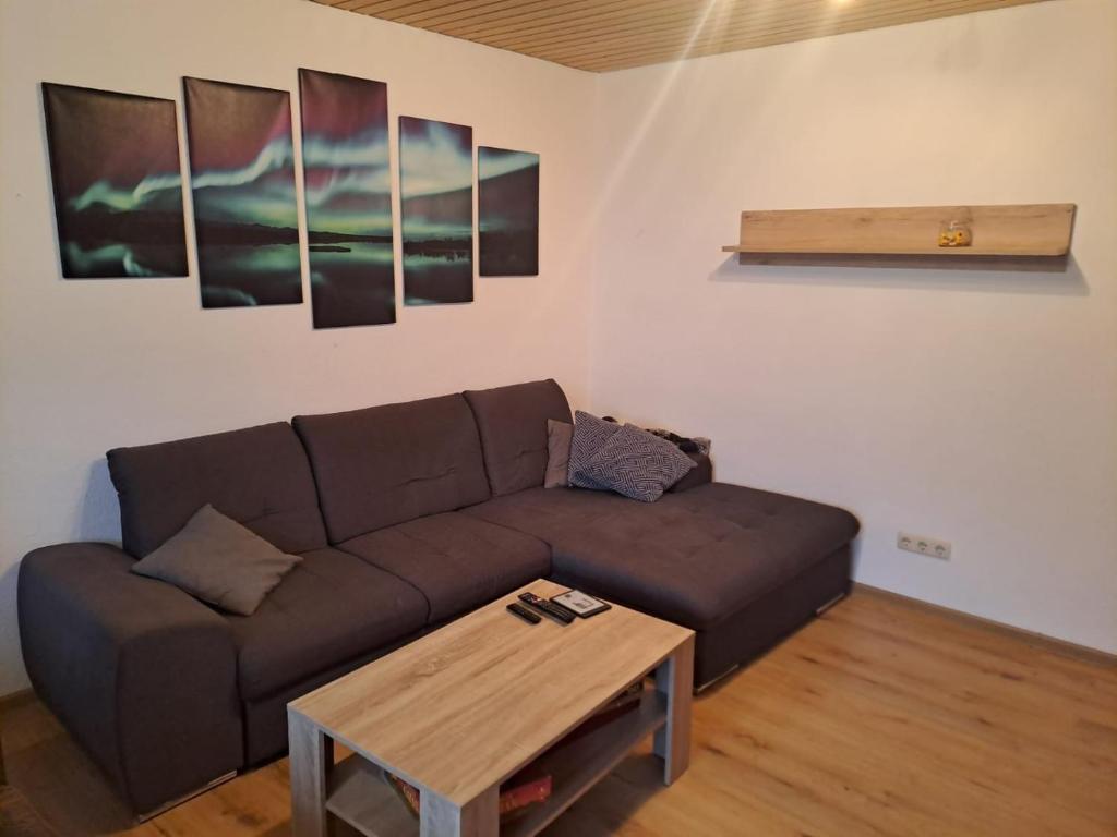 uma sala de estar com um sofá castanho e uma mesa em Zentrale 3-Zimmer-Ferienwohnung em Ilmenau