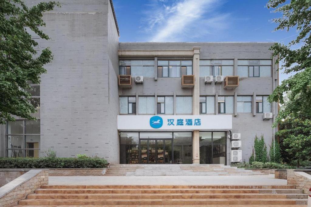 a large building with stairs in front of it at Hanting Hotel Nanjing Xianlin Hongfeng Science and Technology Park in Shifo'an