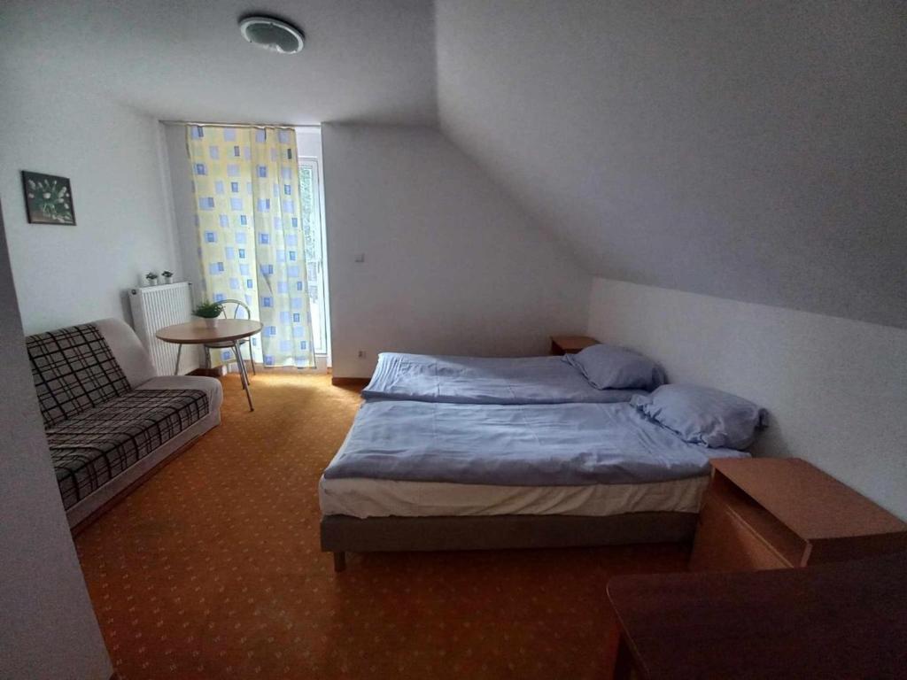 Simple room with two beds, a sofa, and a small table.