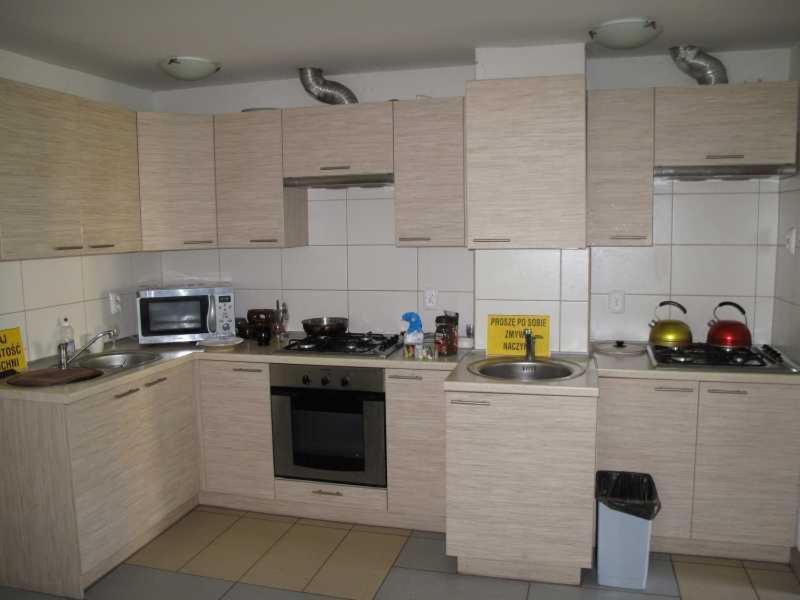 Modern kitchen with light wood cabinets and stainless steel appliances.