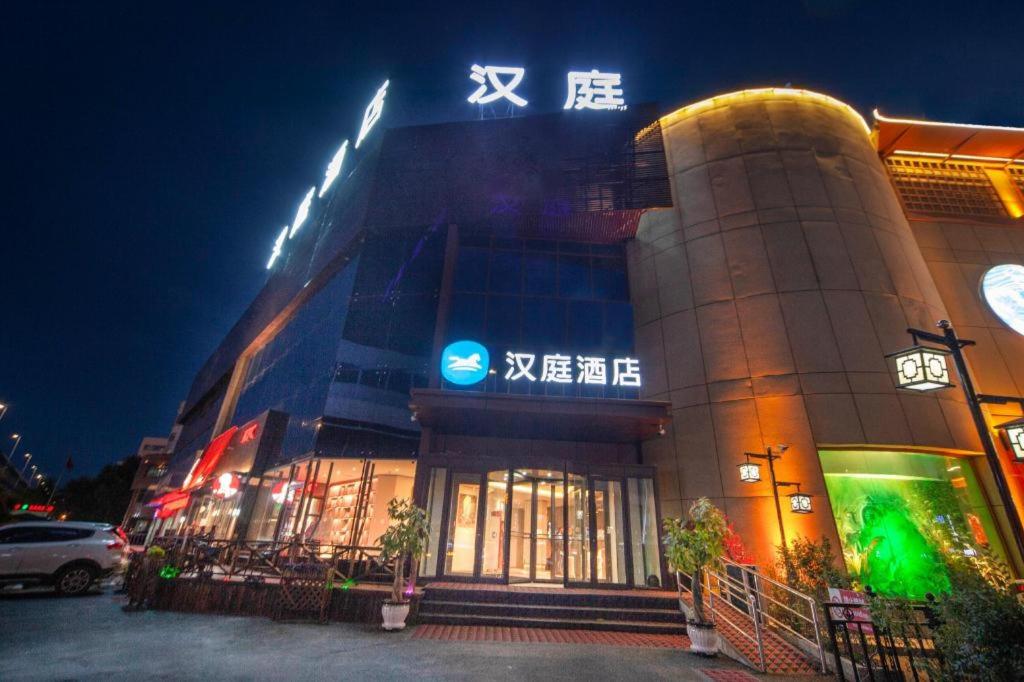 a building with a sign on top of it at night at Hanting Hotel Shenyang Jiangdong Street Metro Station in Shenyang