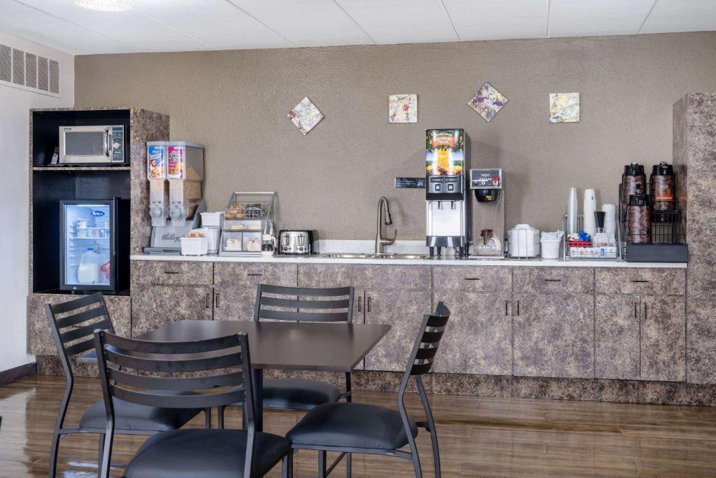 a restaurant with a counter and a table and chairs at Super 8 by Wyndham Owatonna in Owatonna