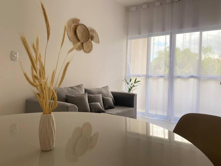 uma sala de estar branca com uma mesa e um sofá em Apto próx centro e faculdade em Umuarama