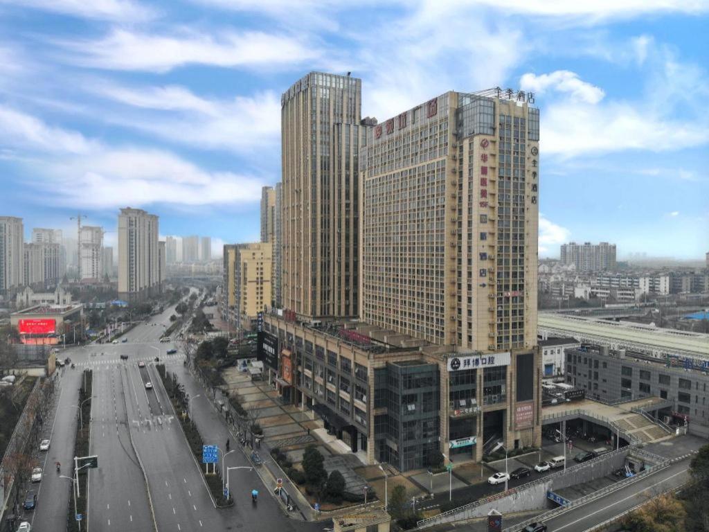 a city with tall buildings and a street with cars at Ji Hotel Zhenjiang Railway Station Nan Square in Zhenjiang