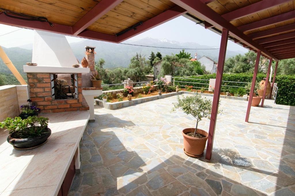 an outdoor patio with a fireplace and potted plants at Aoria Traditional House in Loúlos