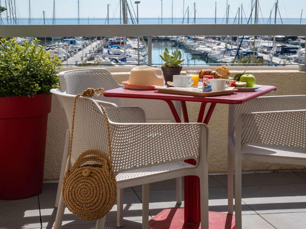 une table avec une assiette de nourriture sur un balcon dans l'établissement ibis budget Menton Bord de Mer, à Menton