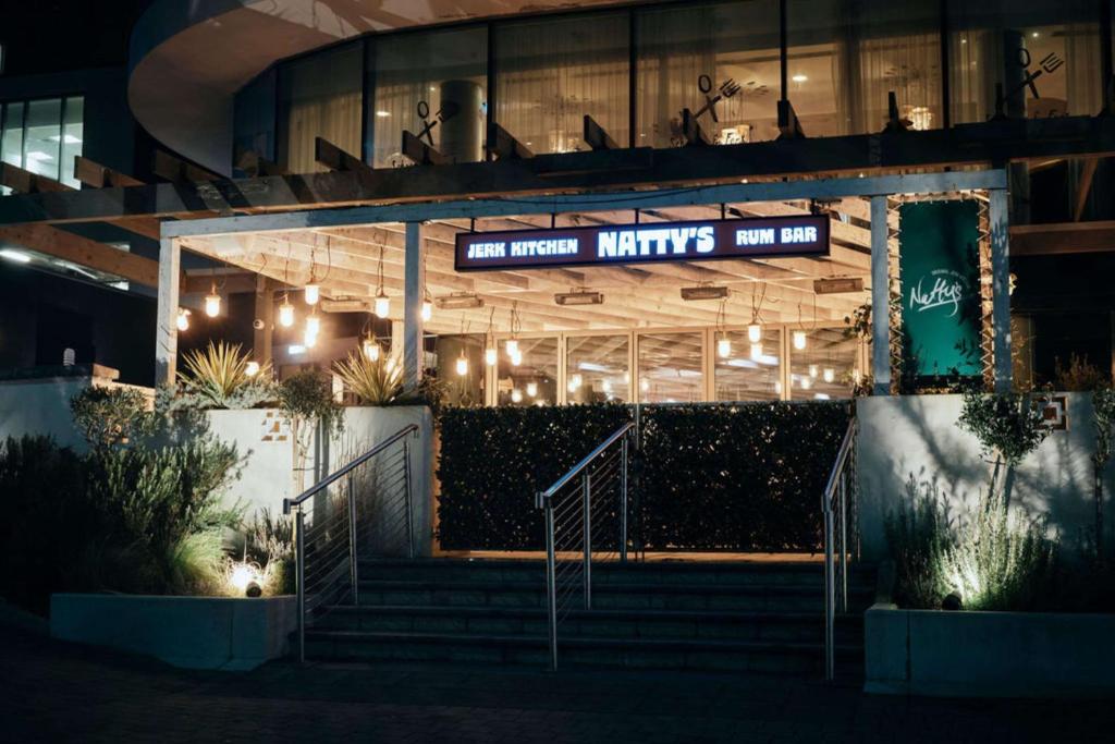 a building with a sign that reads new kitchen kitchens at night at Hilton Bournemouth in Bournemouth