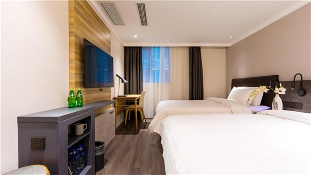 a hotel room with two beds and a desk at Hanting Premium Hotel Shanghai Puqingcheng Zhongxi Road in Qingpu