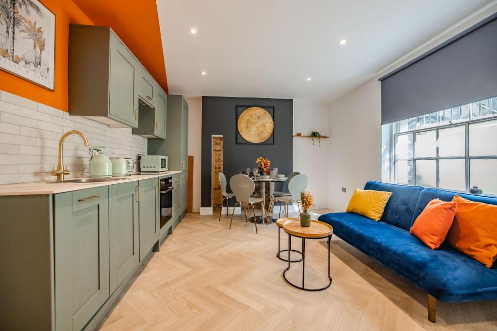 een keuken en een woonkamer met een blauwe bank bij 2 Bedroom 2Bathroom I Next To Brighton Beach I Sleep 6 in Brighton & Hove