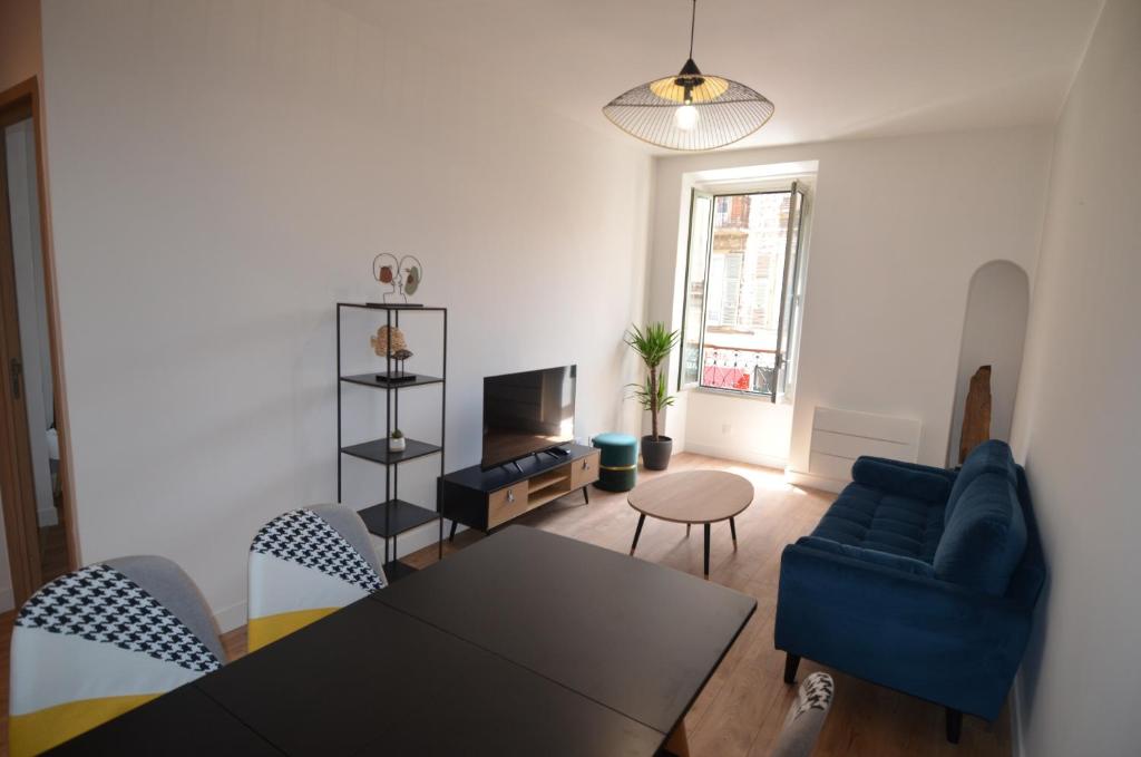 un salon avec un canapé bleu et une table dans l'établissement NAPOLEON - Superbe appartement 2 chambres au cœur du Port de Nice, à Nice