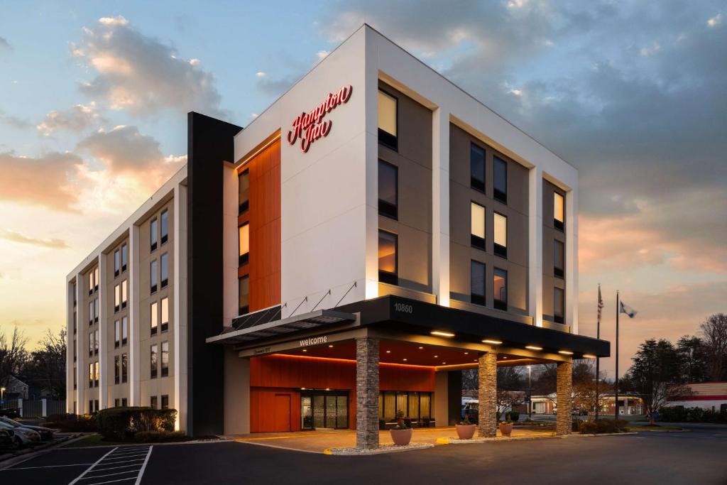 Un edificio con un cartel en el frente. en Hampton Inn Fairfax City, en Fairfax
