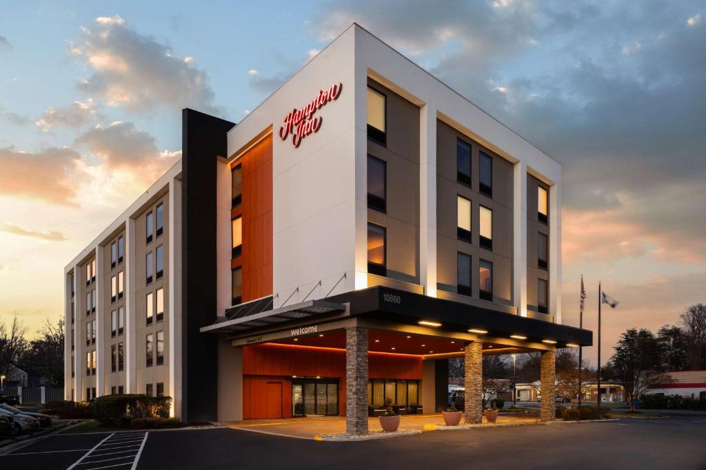 a building with a sign on the front of it at Hampton Inn Fairfax City in Fairfax