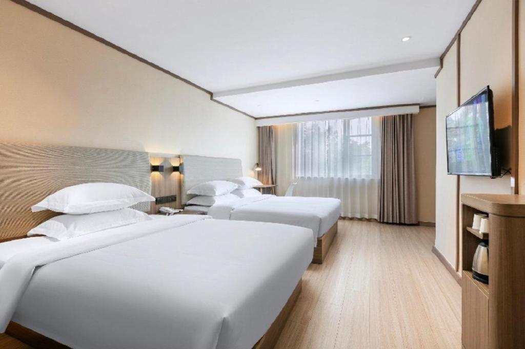 מיטה או מיטות בחדר ב-Hanting Hotel Baotou East Railway Station Zhanqian Square