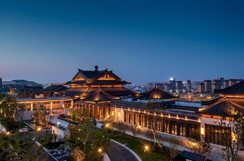 a large building with lights in a city at night at Song Hotel Jinan Fengming in Hongjialou