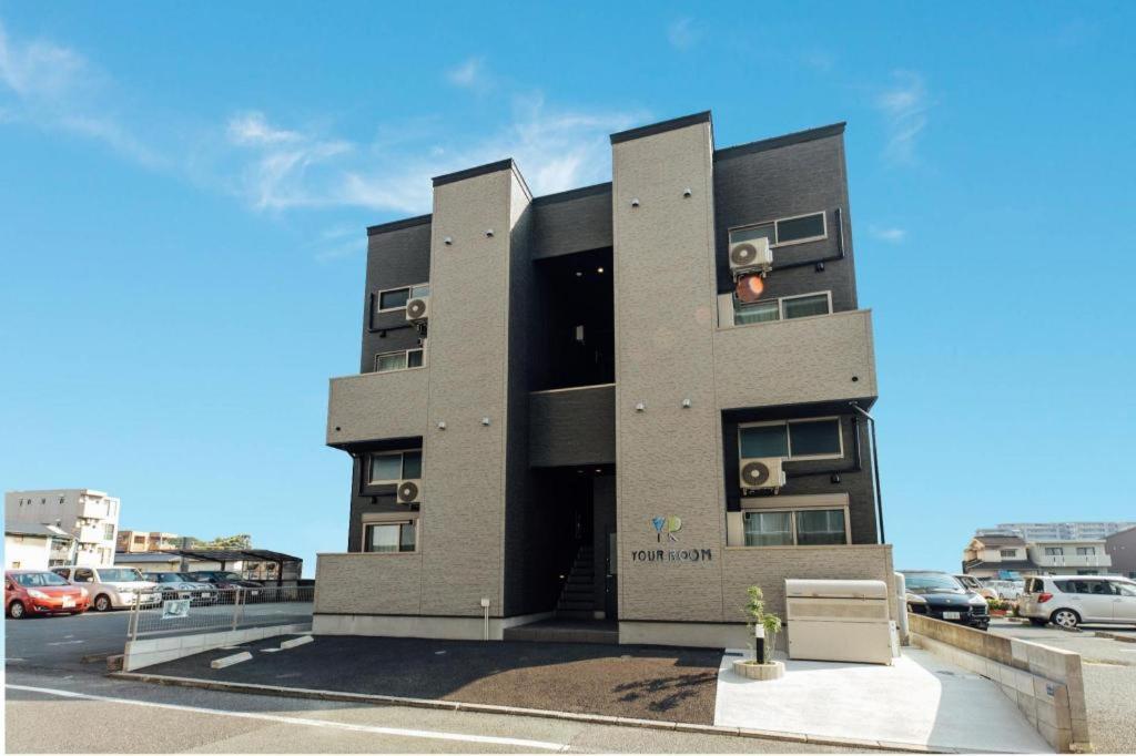 czarny budynek z dwoma balkonami i parkingiem w obiekcie YOUR ROOM Kumamoto Station Little w mieście Hanabatachō