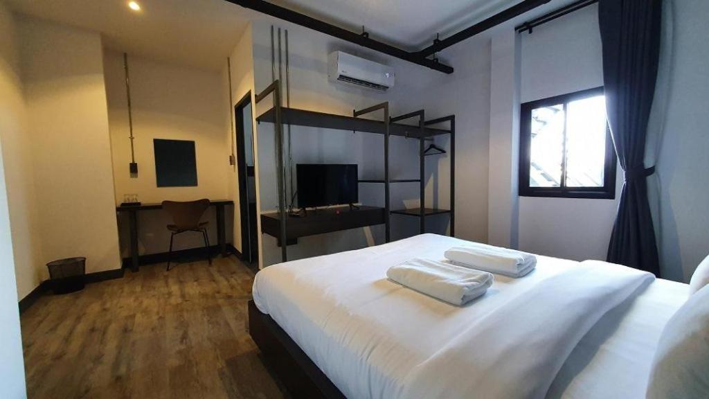 a bedroom with a bed with two towels on it at ZK Hotel Chiangmai in Chiang Mai