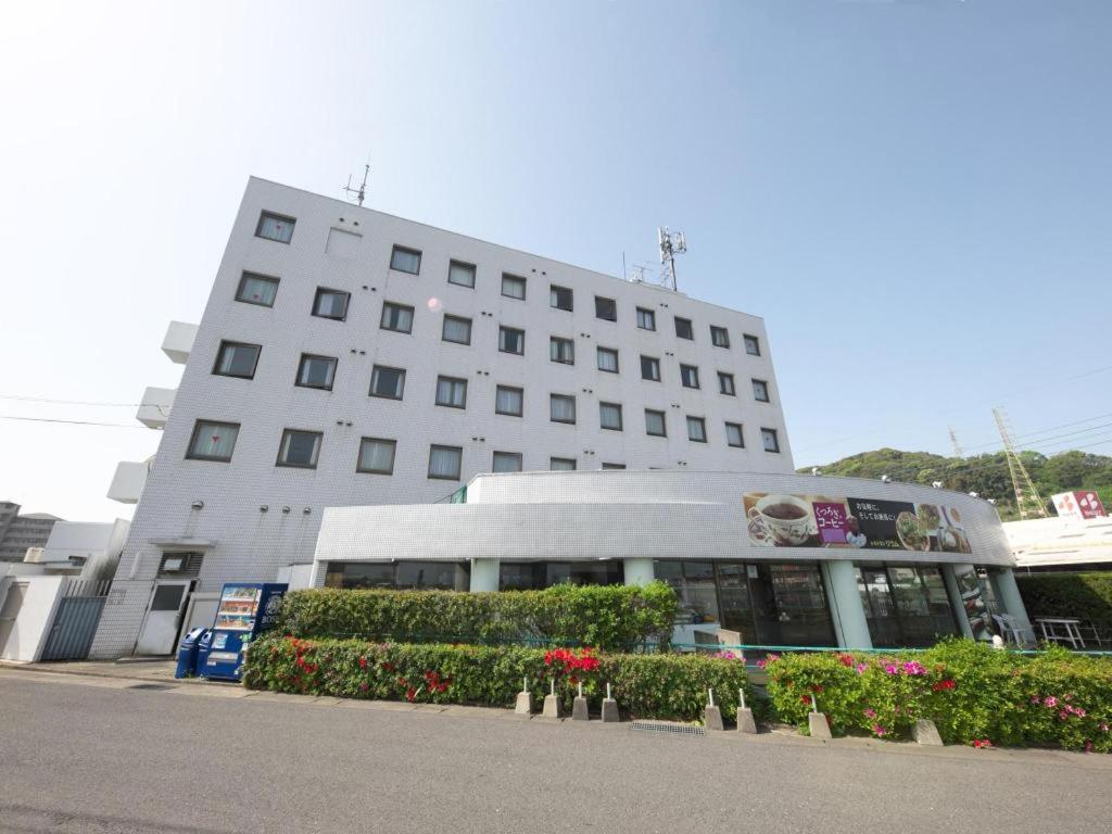 ein großes weißes Gebäude mit Blumen davor in der Unterkunft Togitsu Yasuda Ocean Hotel in Togitsu
