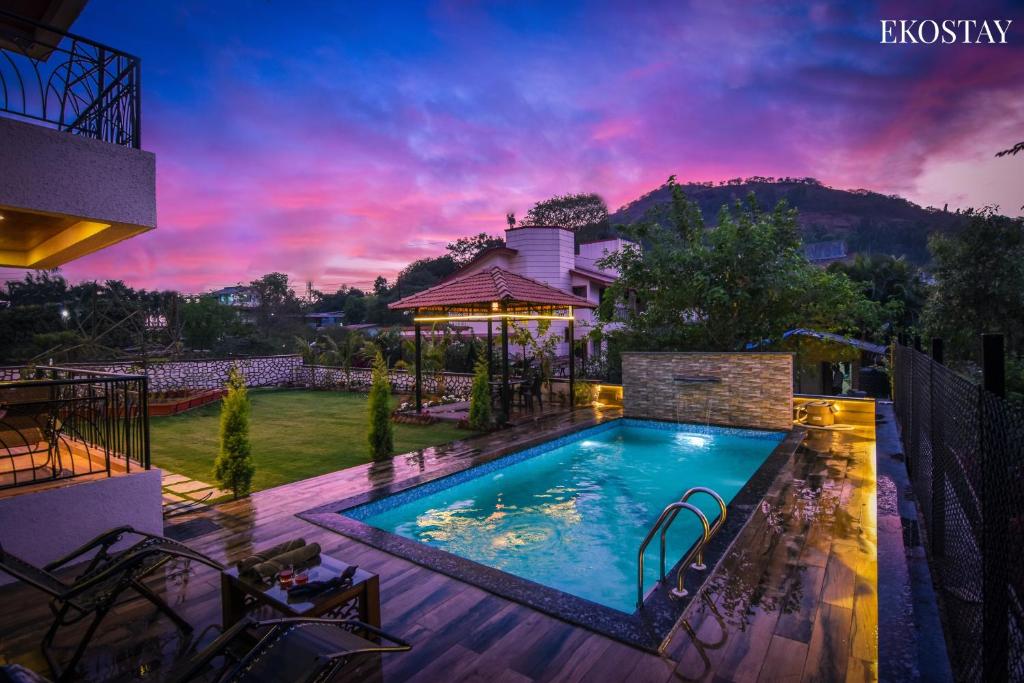 a swimming pool in the backyard of a house at EKOSTAY- GOLD - Titanium Villa in Lonavala