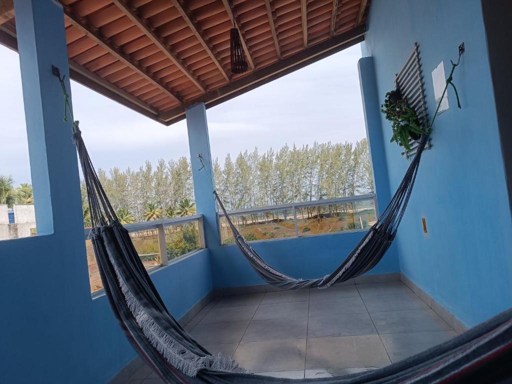 a hammock on the balcony of a house at Kitnets Renascer Beach in Guaibim