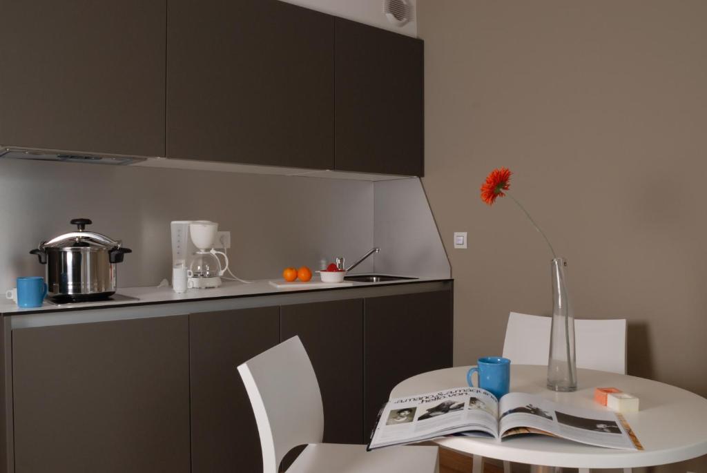 a kitchen with a table with a vase and a book at Temporesidence Cathedrale in Bayonne