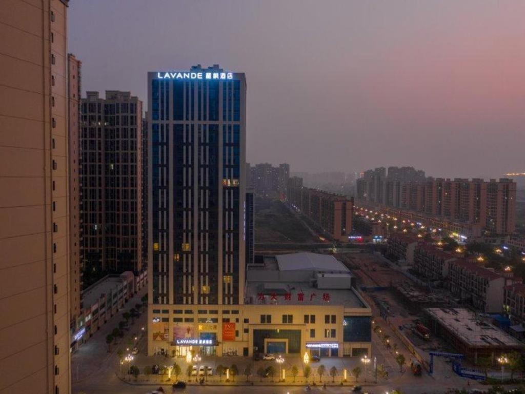 un grand bâtiment avec un panneau dans une ville dans l'établissement Lavande Hotel Huizhou Shiwan, à Shiwan