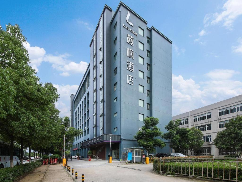 a tall grey building with a sign on it at Lavande Hotel Wuhan 2nd Guanggu Road in Liufangling